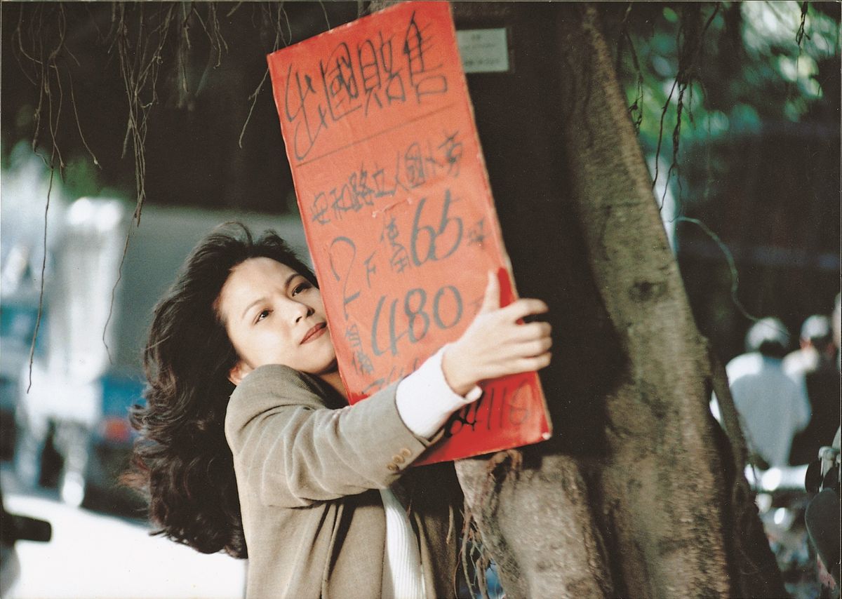 Realtor May Lin (Yang Kuei-mei) hangs a sign on a tree in Tsai Ming-liang's Vive L'Amour.