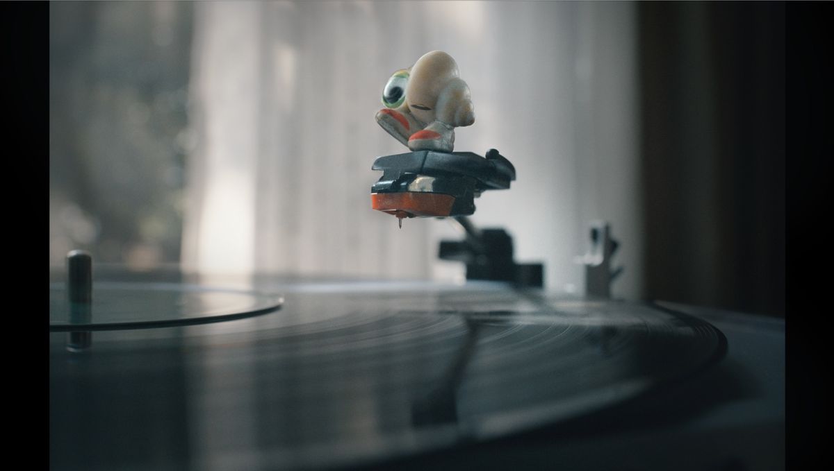 An image of Marcel, the Shell with Shoes On, perched on the needle of a record player. 