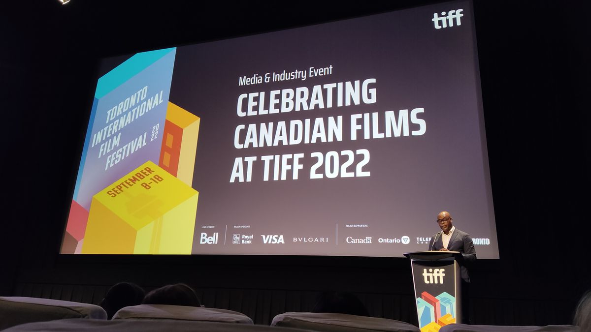 TIFF CEO Cameron Bailey stands at a lectern in front of a large image reading "Celebrating Canadian Films at TIFF 2022". 