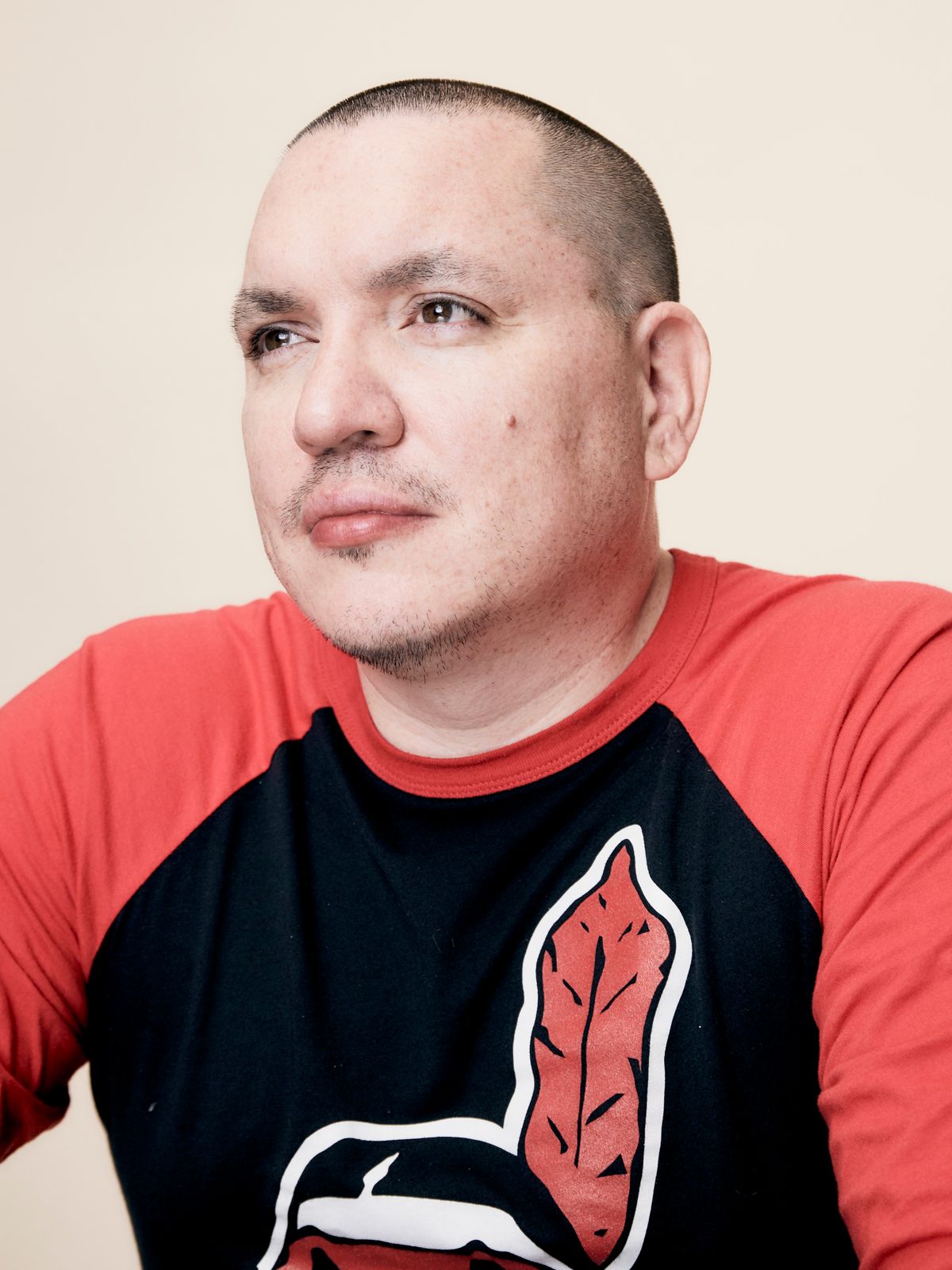 A promotional image of Jeff Barnaby wearing a shirt featuring the Cleveland Indians' racist mascot Chief Wahoo. Because